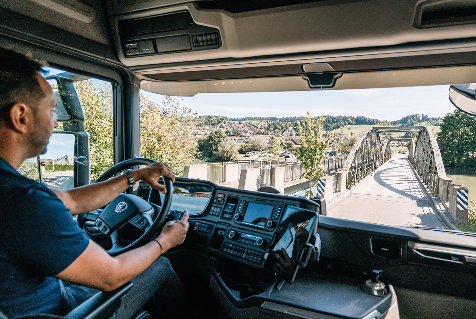 Roland Koch Transporte Schweiz: LKW-Fahrer überquert Brücke mit Landschaftsblick