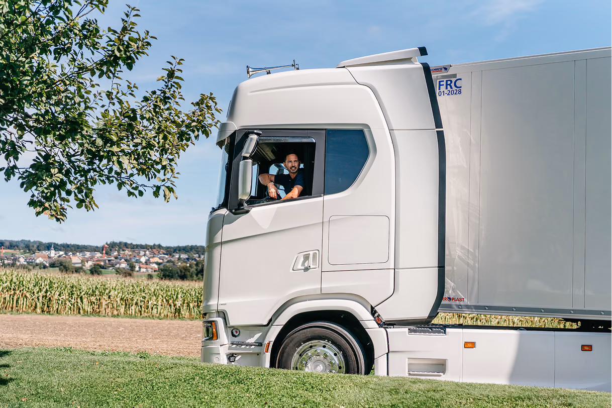 Roland Koch Transporte Schweiz LKW fährt durch ländliche Landschaft