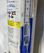 Close-up of a medical manometer showing pressure measurements with a blue column and measurement markings.