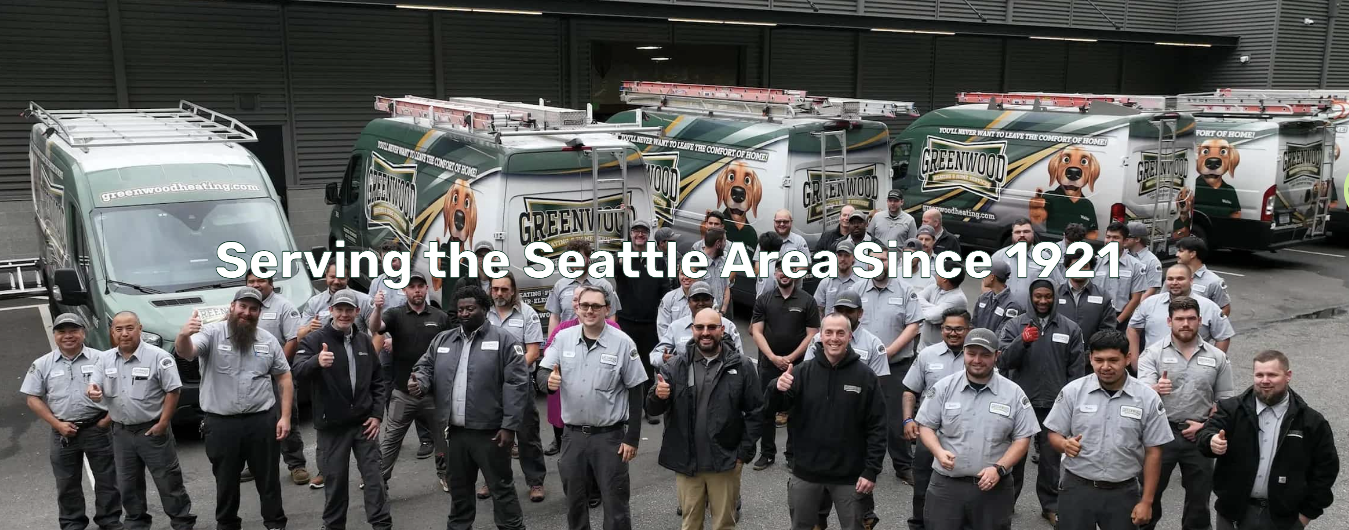 Greenwood Heating & Home Services team posing in front of their branded service vans in the Seattle area, with text reading 'Serving the Seattle Area Since 1921'