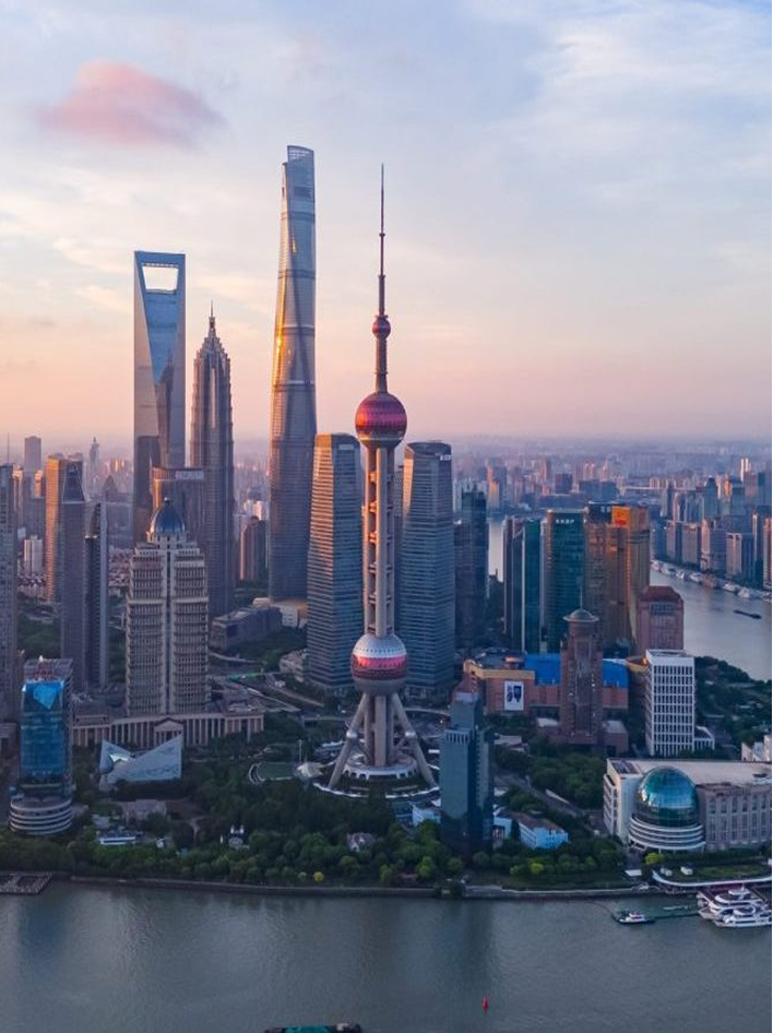 Shanghai skyline featuring the Oriental Pearl Tower and modern skyscrapers at sunrise.