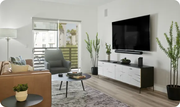 Modern living room with minimalist decor, neutral tones, and natural light from large windows.