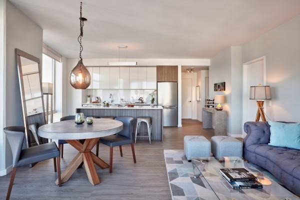 Modern open-concept living space with sleek kitchen, dining area, and cozy seating arrangement.
