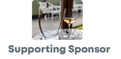 A glass of wine beside a Synergies award trophy, labeled "Supporting Sponsor."