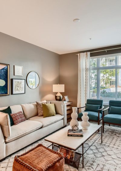 A modern living room with neutral tones, stylish furniture, and natural light from large windows.