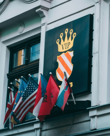A building facade with a VIP crest sign and multiple international flags displayed below.