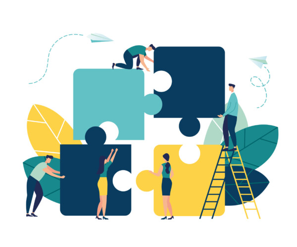 Team collaboration concept with people assembling large, colorful puzzle pieces.