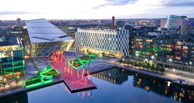 Grand Canal Square in Dublin, featuring modern architecture and vibrant lighting at dusk.