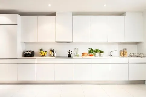 Modern white kitchen with minimalist cabinets, sleek appliances, and organized countertop essentials.