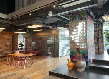 Modern workspace with vibrant decor, wooden flooring, playful furniture, and