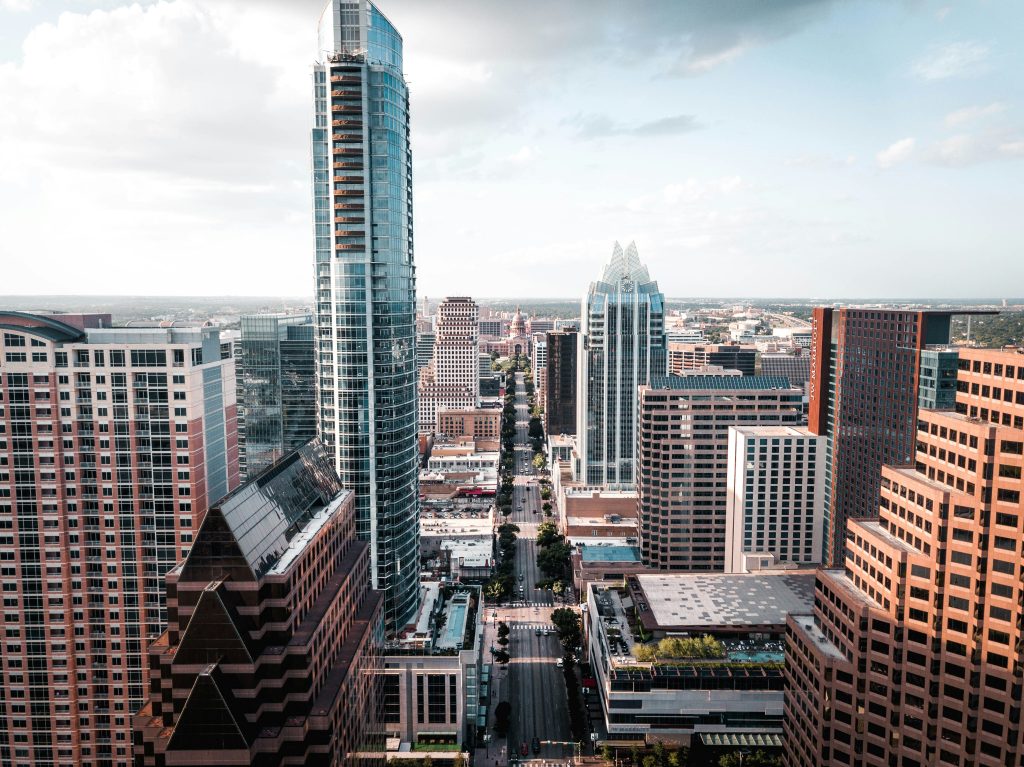A modern cityscape featuring tall skyscrapers, urban streets, and a mix of architectural styles.