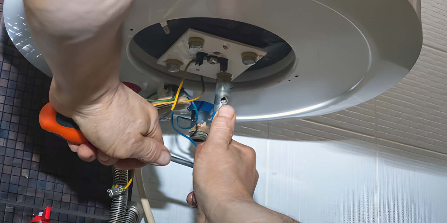 Technician inspecting a water heater leaking into a false ceiling in a Dubai apartment