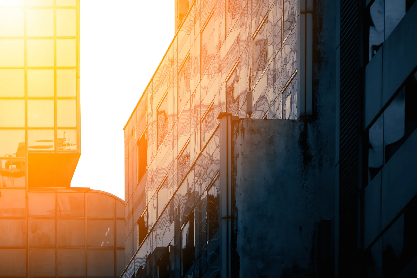 Sunlight reflecting off glass windows on modern buildings during sunset or sunrise.