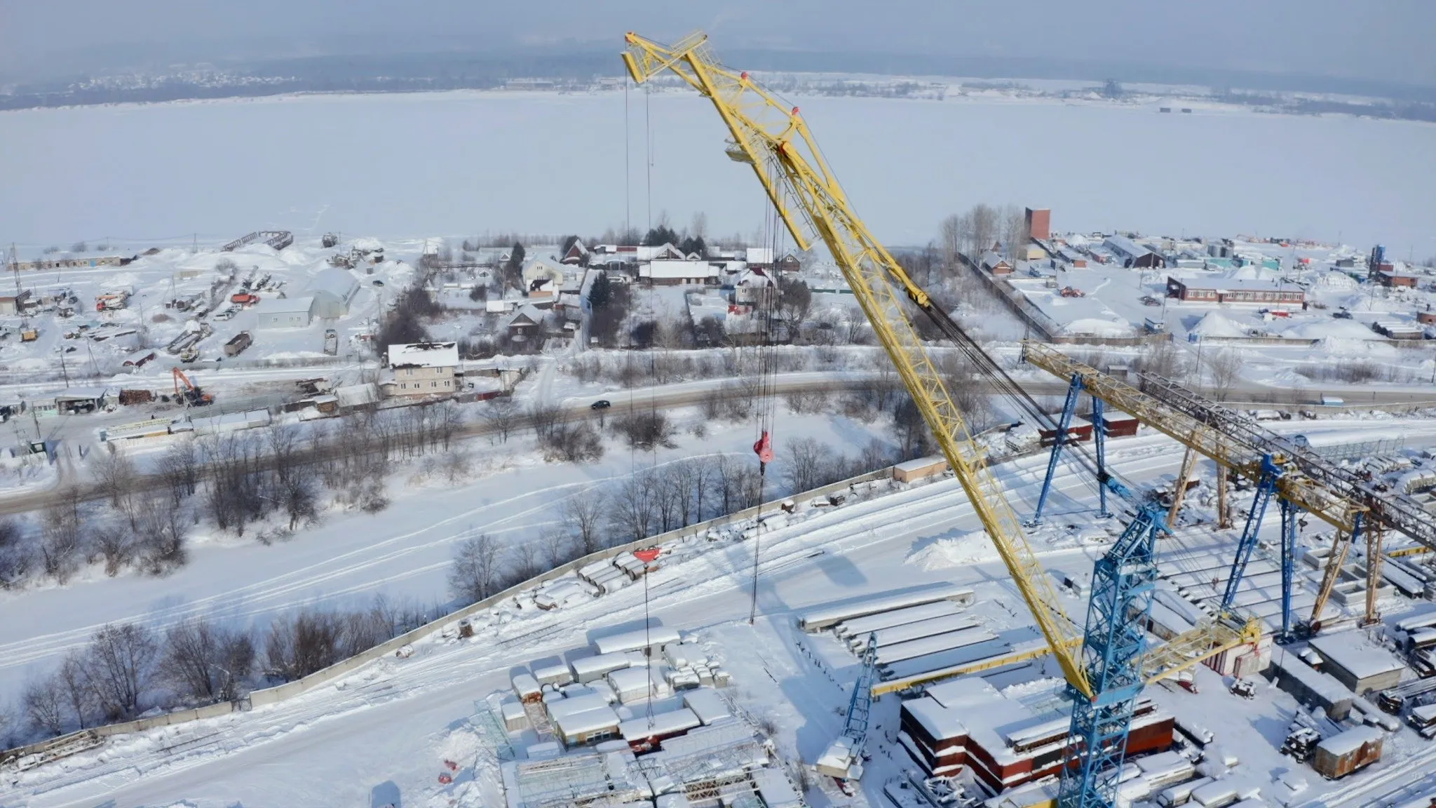 Aerial view of yellow construction crane in snow.
