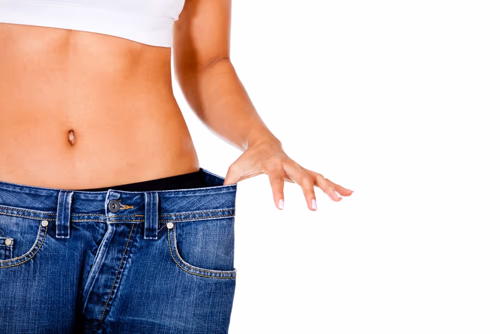 Slim woman with oversized jeans after weight loss