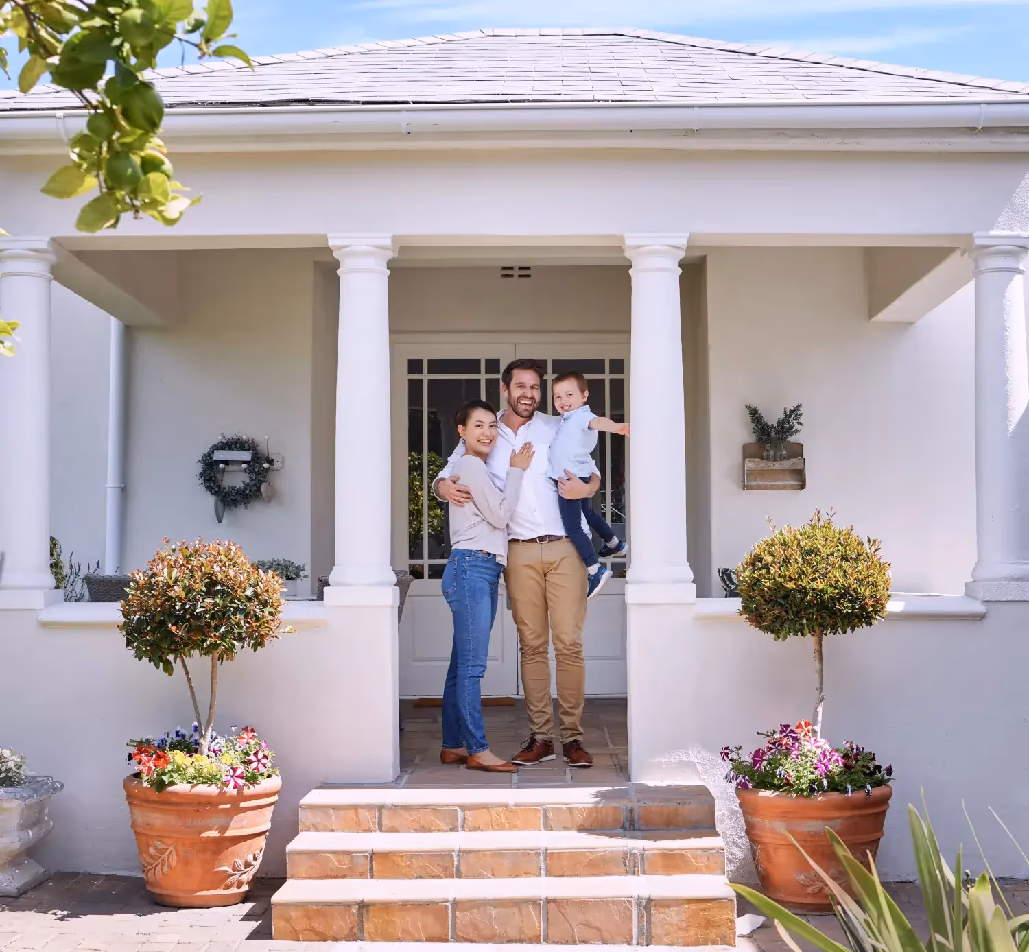 A happy family standing in the entranceway of their house