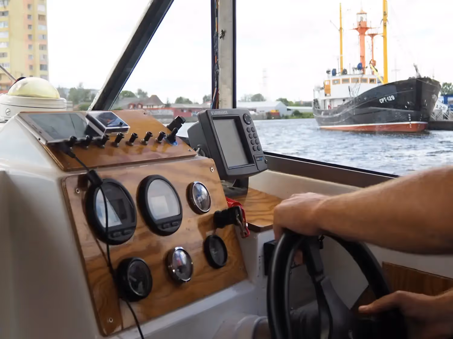 Hands on the boat’s steering wheel