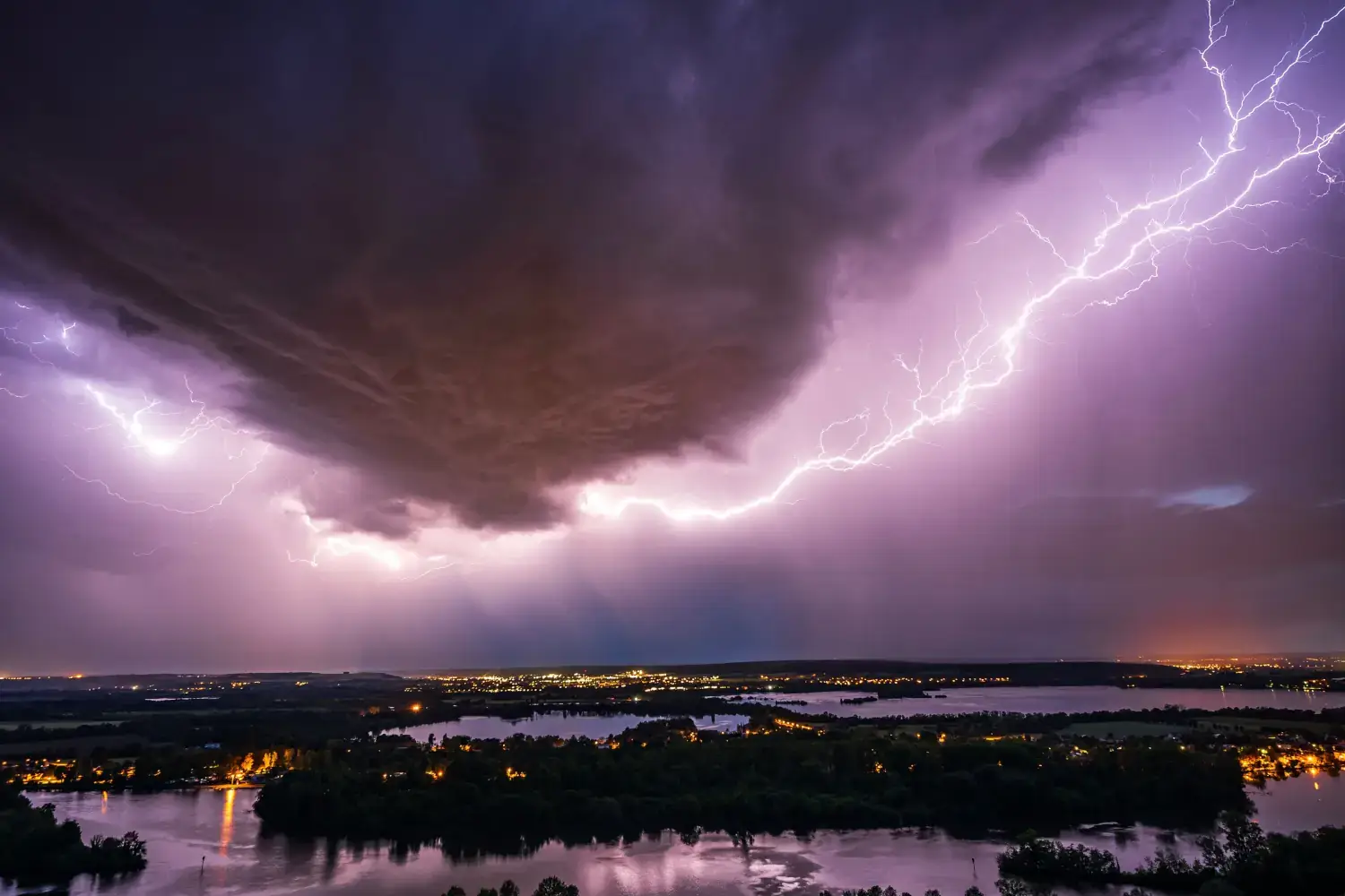 Lightning bolt arcs across a stormy night sky.