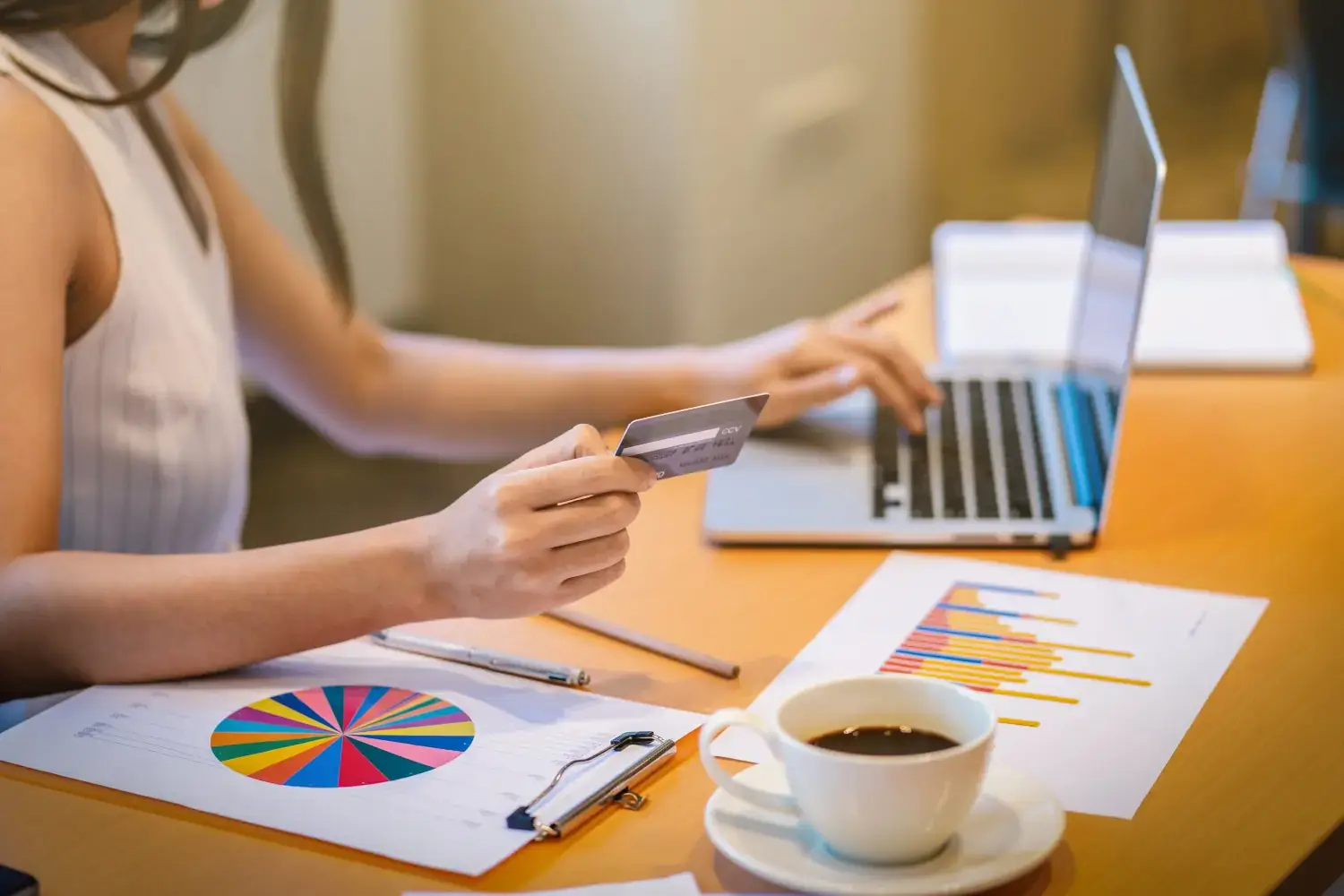 Woman paying online with credit card at desk.