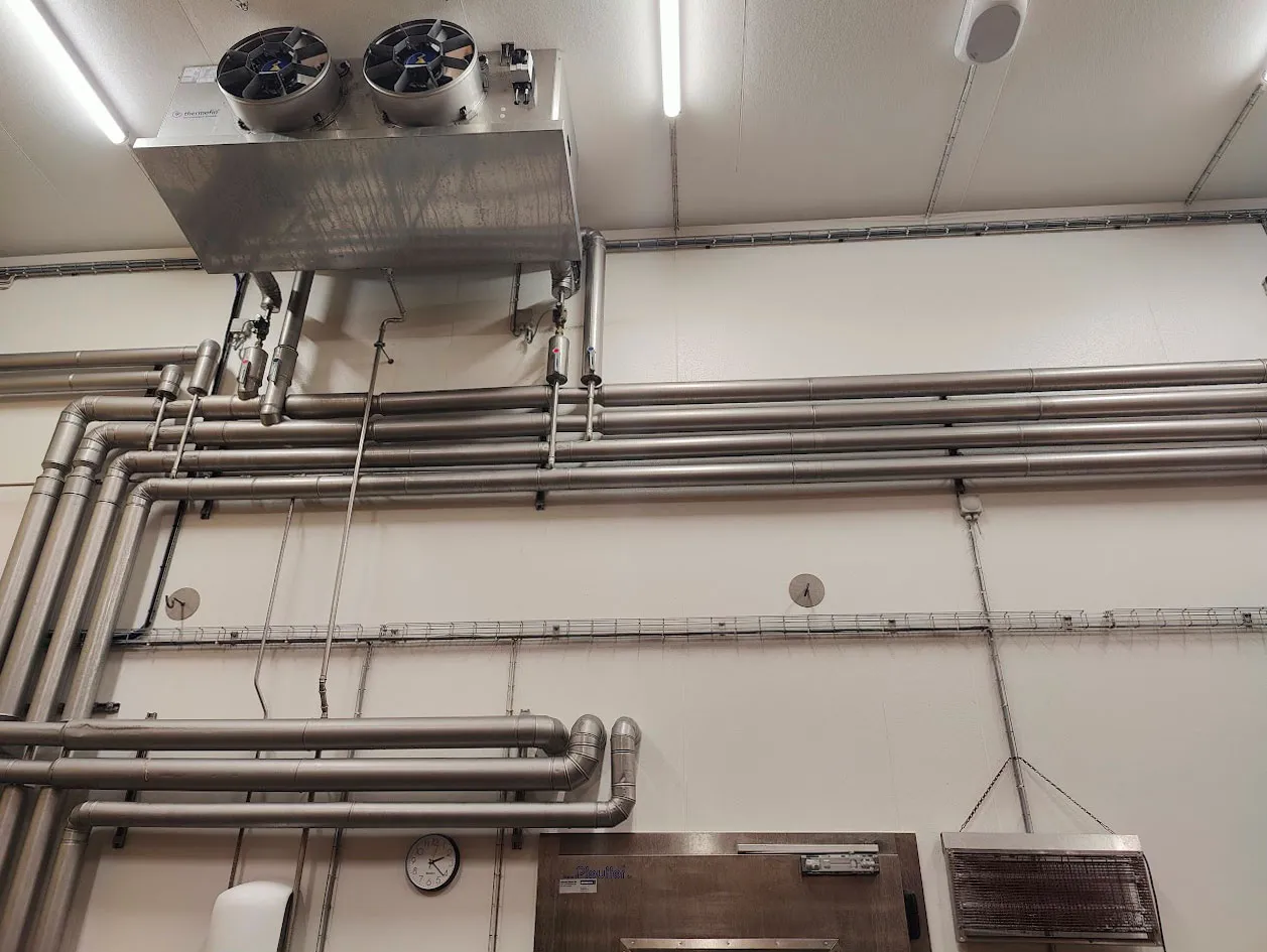 Vous voyez ici l'installation d'un réfrigérateur dans une salle de sport pour l'entreprise J. Le réfrigérateur propose des collations et des boissons saines aux membres.