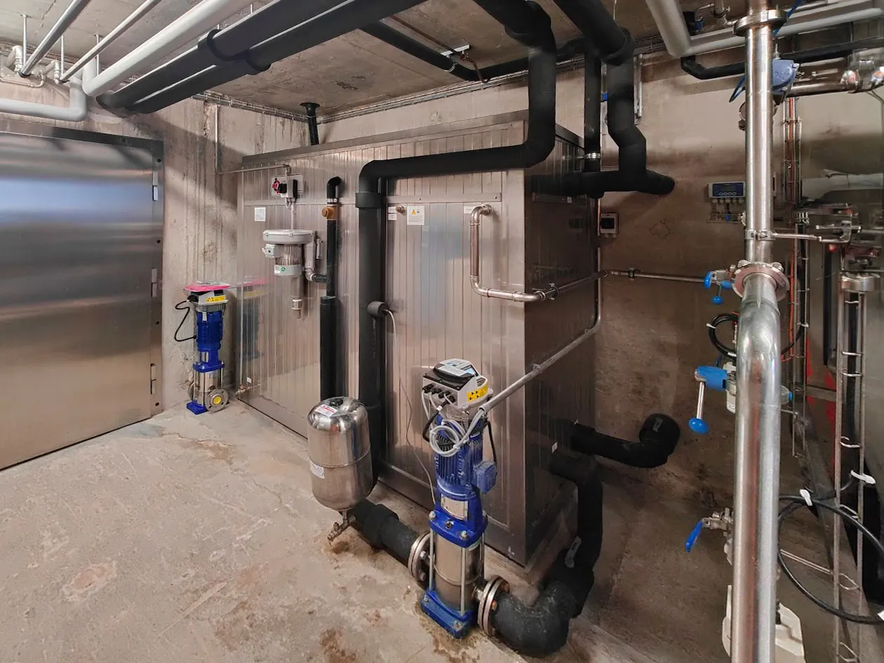 Vous voyez ici l'installation d'un réfrigérateur dans une salle de sport pour l'entreprise J. Le réfrigérateur propose des collations et des boissons saines aux membres.