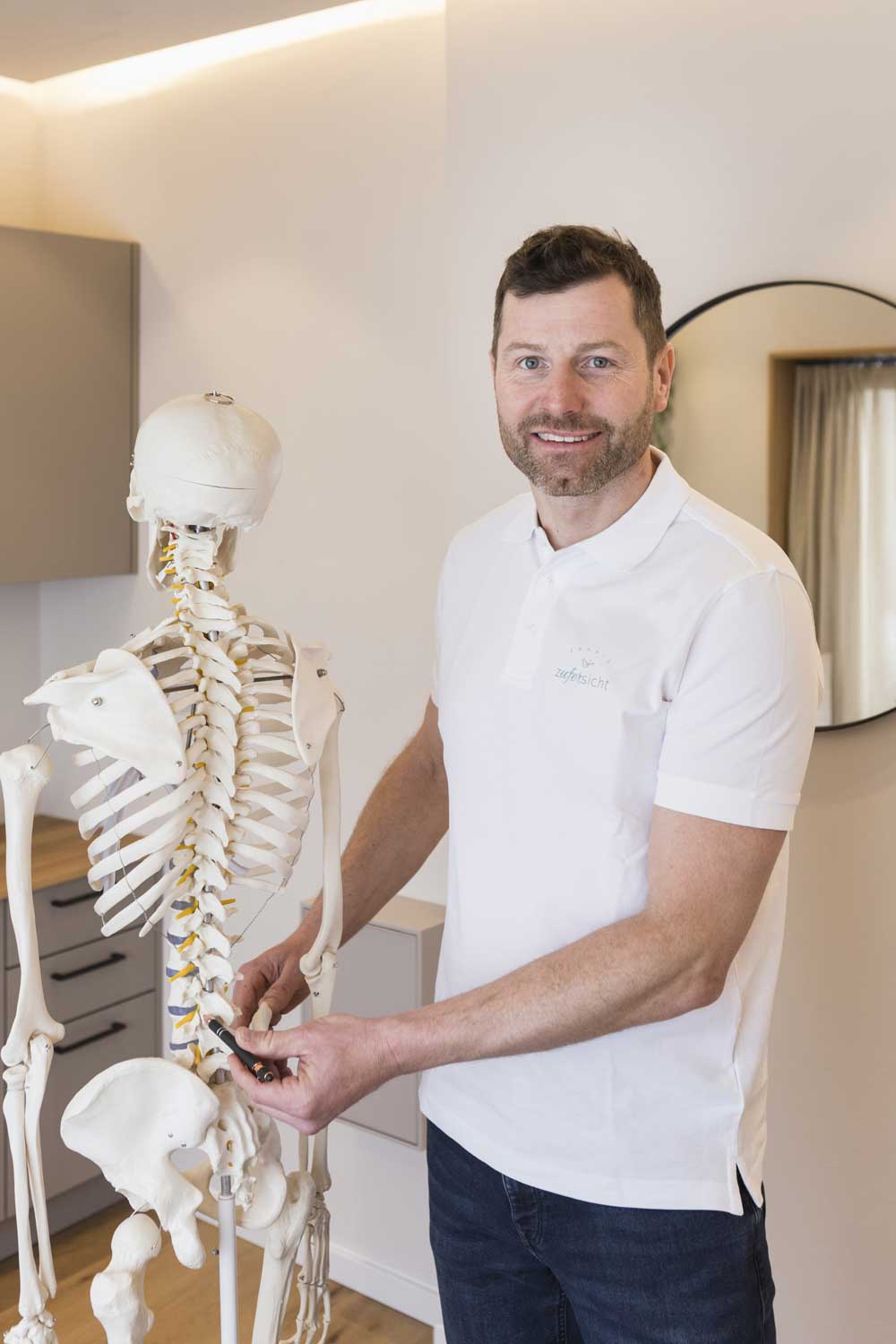 Erklärung der Wirbelsäulenanatomie am Skelettmodell zur Veranschaulichung von Rückenbeschwerden