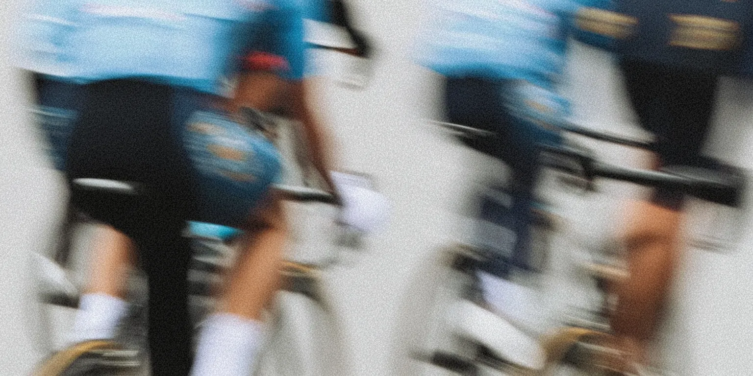 Motion-blurred cyclists from rear perspective emphasizing speed and movement