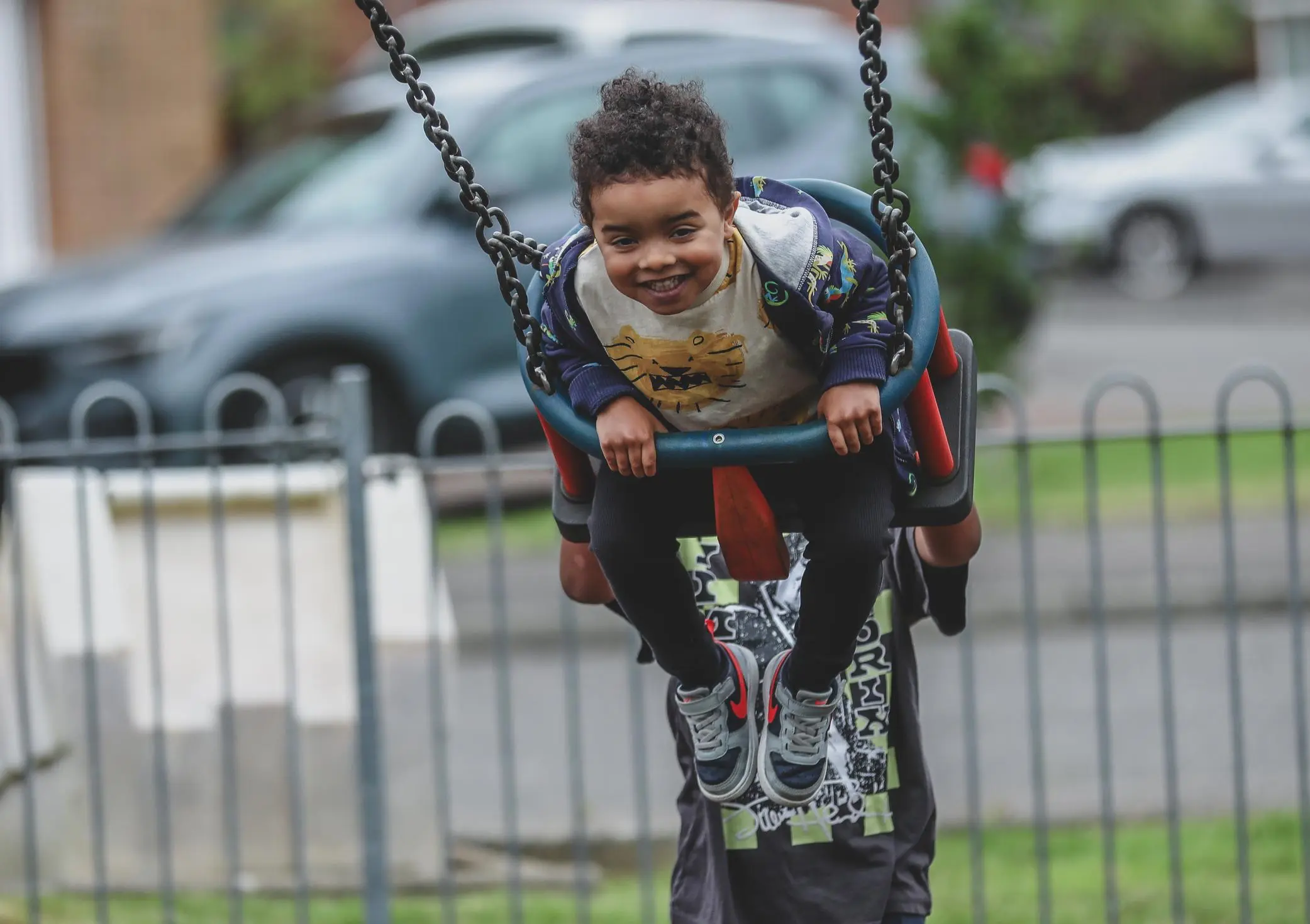 Child holding onto chains while swinging at a playground