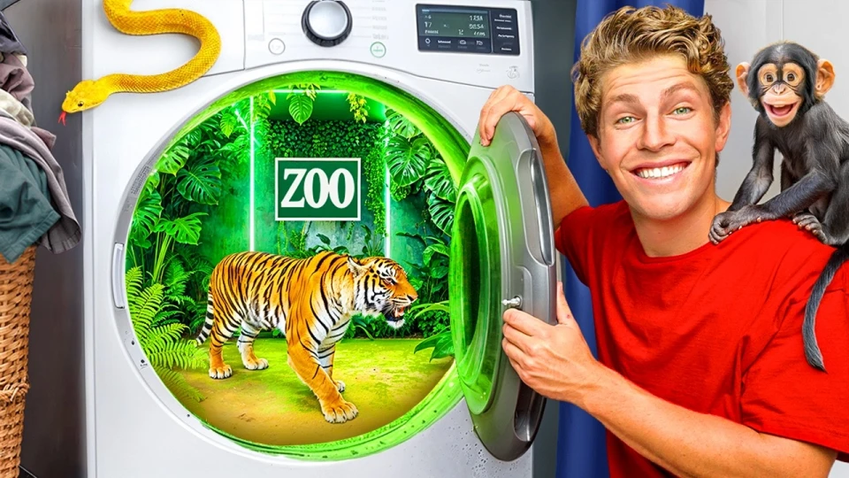 A smiling young man in a red shirt opens a washing machine door revealing a miniature zoo inside with a tiger on the green floor and a neon 'ZOO' sign on the back wall, while a monkey sits on his shoulder and a yellow snake rests on a basket of laundry nearby.