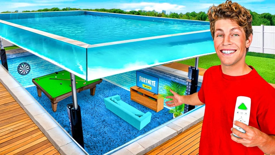 A young man in a red shirt holding a remote, standing next to a transparent elevated swimming pool above a small living space that includes a blue sofa, a TV displaying 'Fortnite', a pool table, and a dartboard.