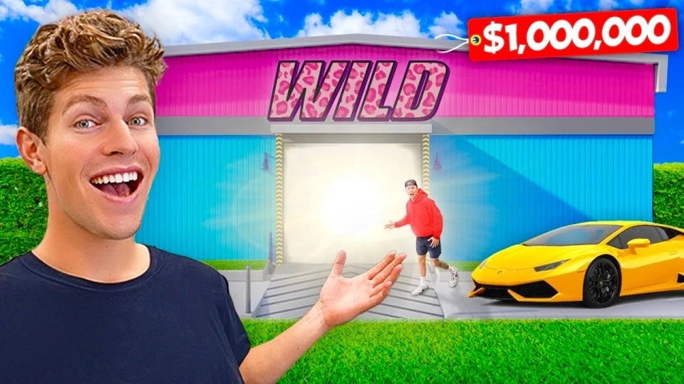 A man with curly brown hair smiling and gesturing towards a colorful building with the word 'WILD' in large pink letters on it. Another man in a red hoodie and black shorts is standing near a bright light at the entrance, and a yellow sports car is parked nearby on a green lawn under a blue sky.