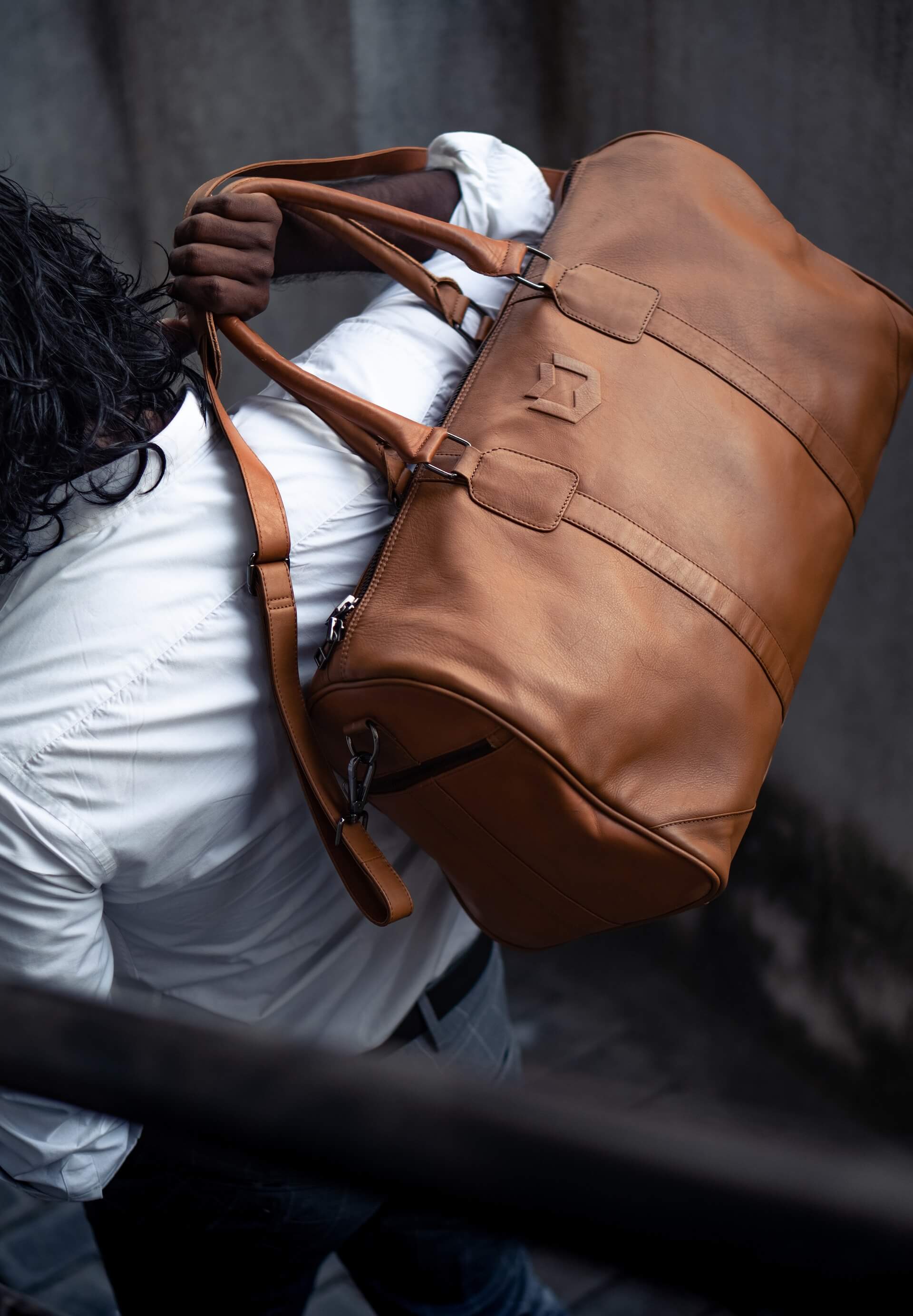 Man holding a brown leather bag