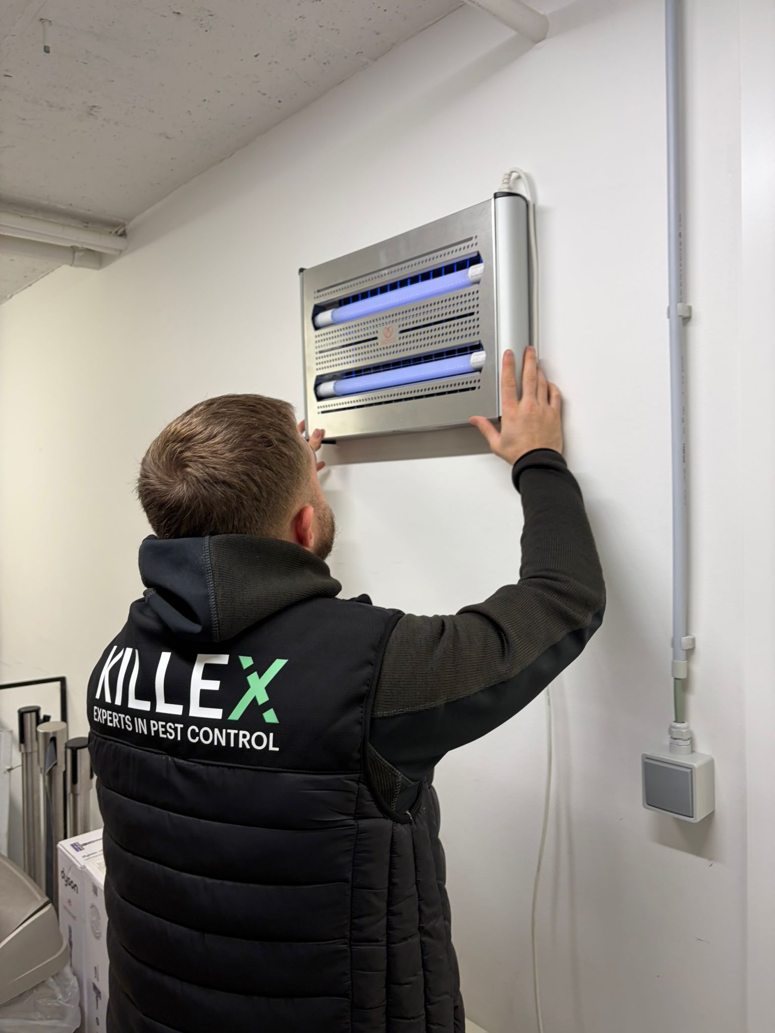 Killex-technicus installeert vliegenlamp bij een klant