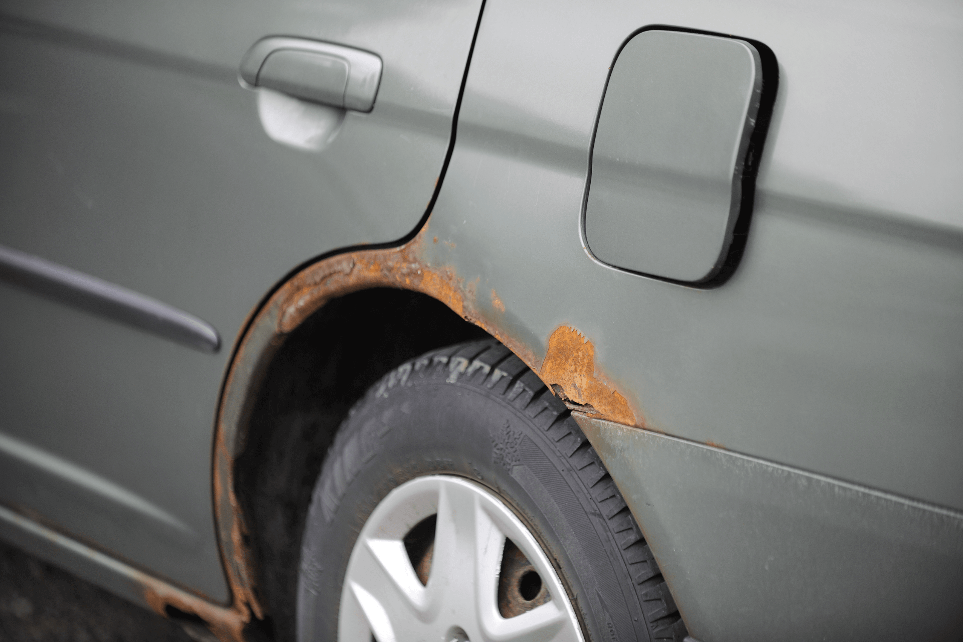 voiture avec de la rouille perforante au niveau de l’aile au dessus de la roue arrière