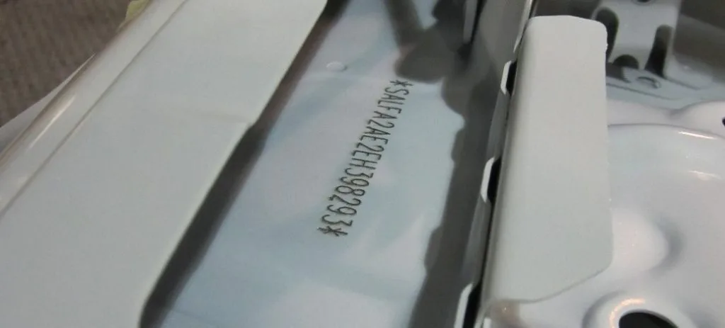 Conducteur installant des chaînes à neige sur un pneu de voiture dans un environnement enneigé