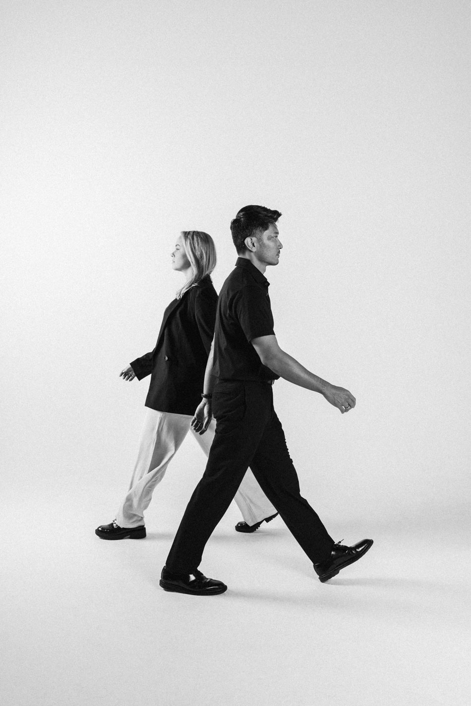 A photo of Kate Karanges and Roi Toledo walking in the opposite direction to show movement. Editorial Style in black and white.