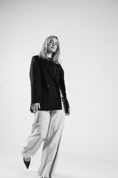 A photo of Kate Karanges in editorial style walking in confidence. She is the founder and director of The Latest.