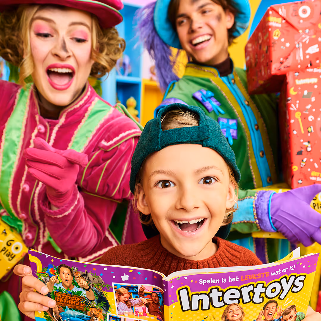 Boy looking to the Sinterklaas Intertoys Book, sorrounded by "piets"