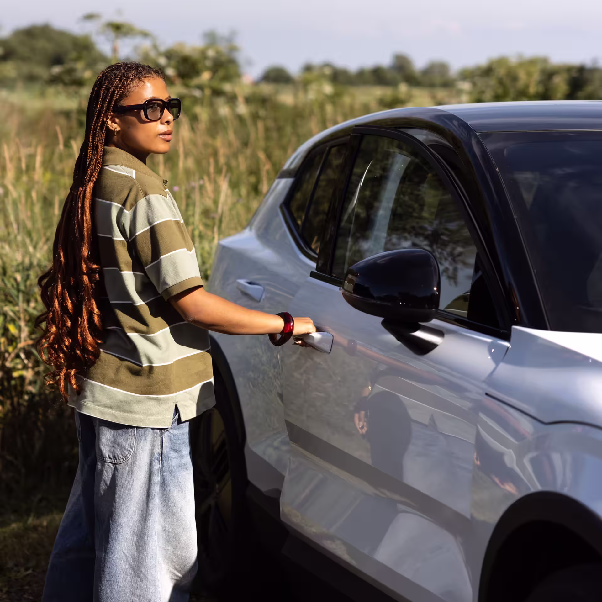 a young lady opening the door to a volvo