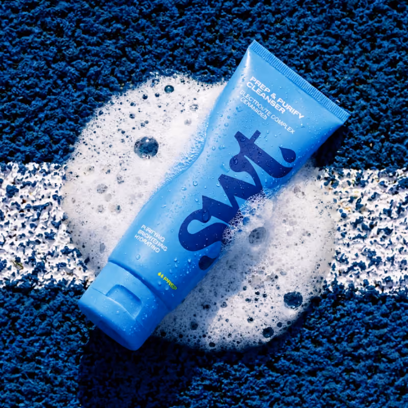 Blue bodywash rests on a tennis court, adding a quirky touch to the athletic setting.
