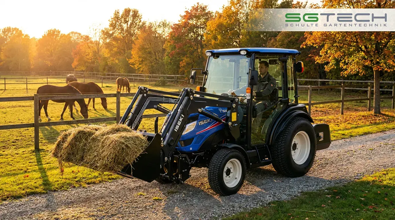 Iseki TH5420AHLK Traktor bei der Heuernte auf einer Pferdekoppel im Herbst.