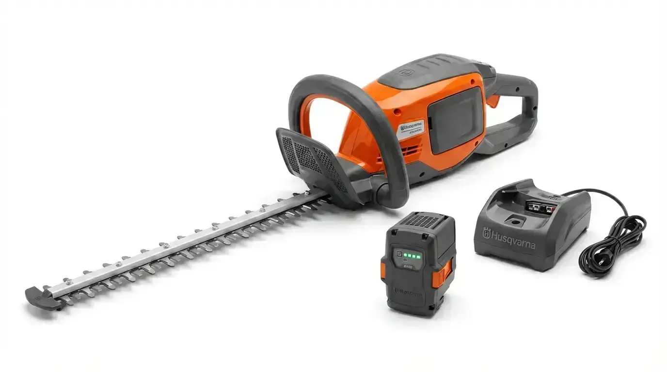 Husqvarna 215IHD45 Akku-Heckenschere mit Akku und Ladegerät auf weißem Hintergrund.