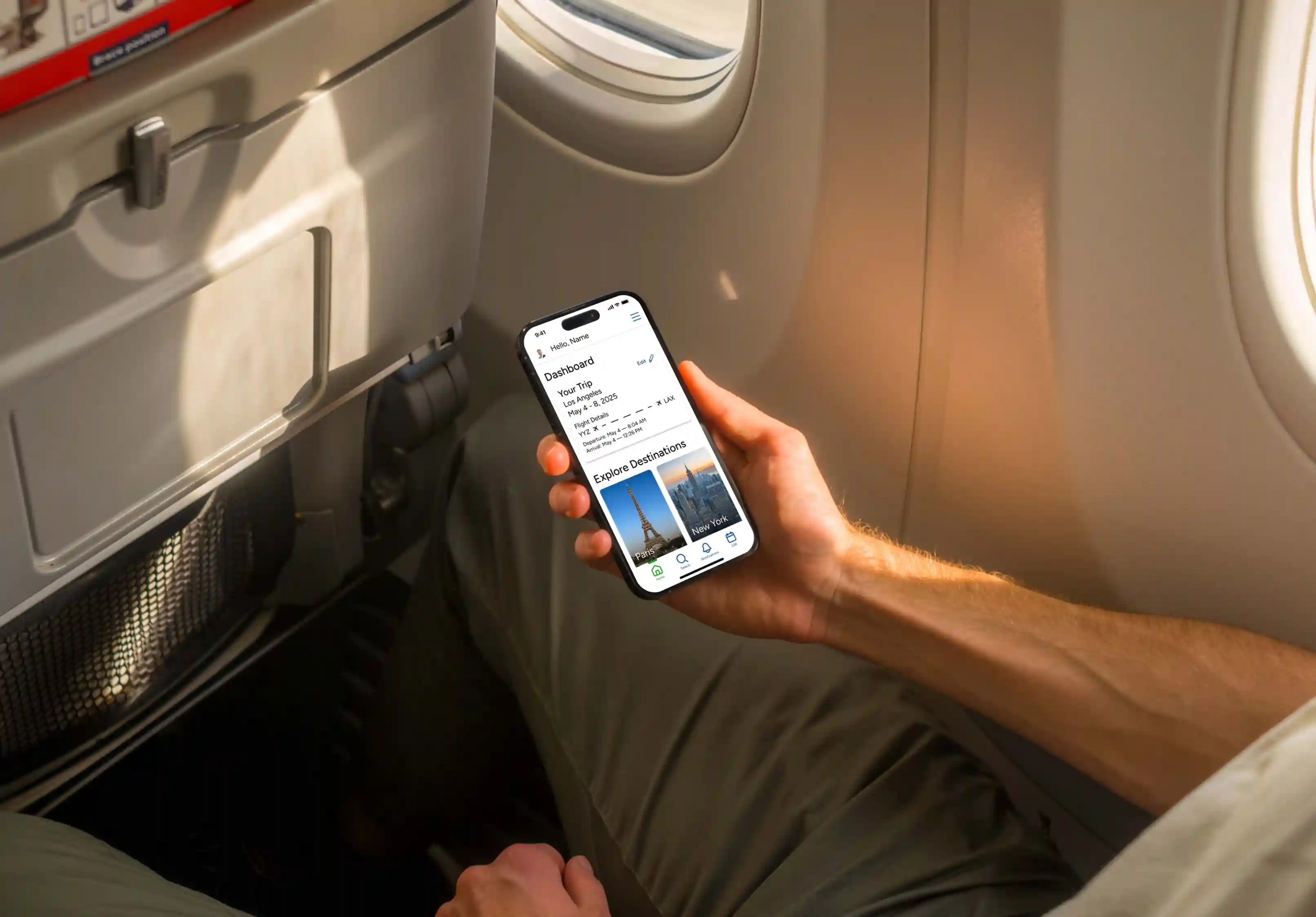 Person seated by an airplane window holding a smartphone displaying a travel app dashboard with trip details and destination options.