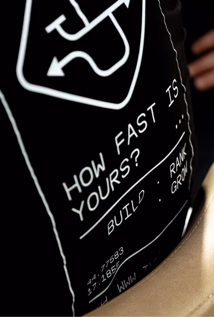 Close-up of black fabric with white text reading 'How fast is yours?' and other partial data.
