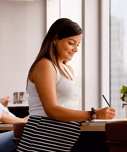 A pregnant woman working in a notebook