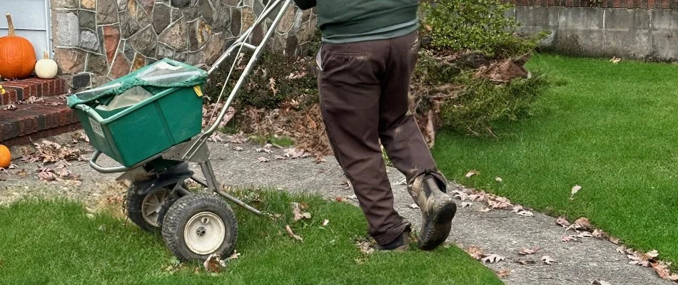 Crew Spreading Fertilizer Treatment On Lawn