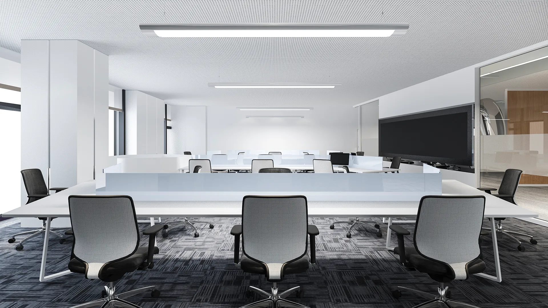 Modern office workspace with white desks, mesh office chairs, glass partitions, and overhead fluorescent lighting.