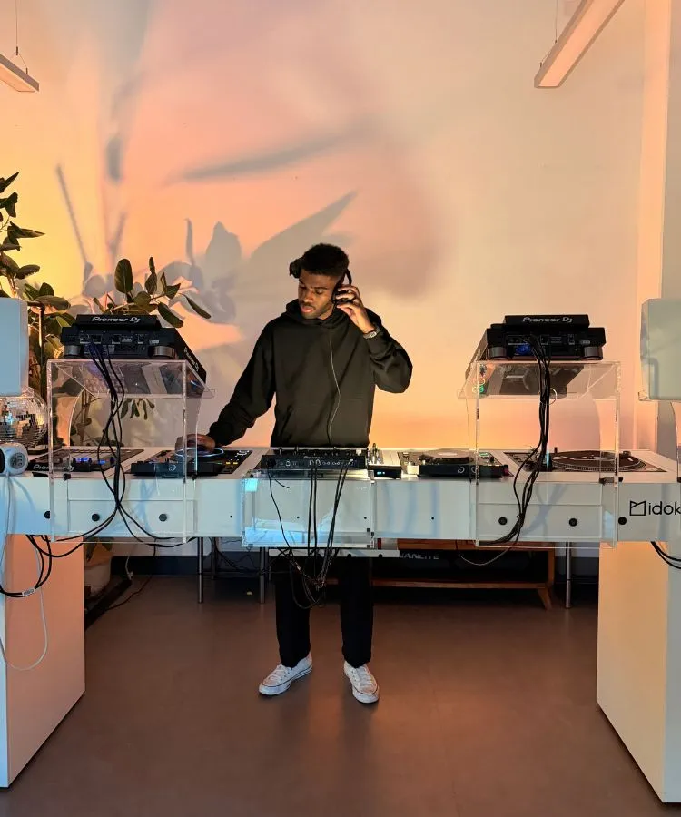 A man DJing in Studio One at London Sound Academy at the helm of an impressive custom made white DJ booth