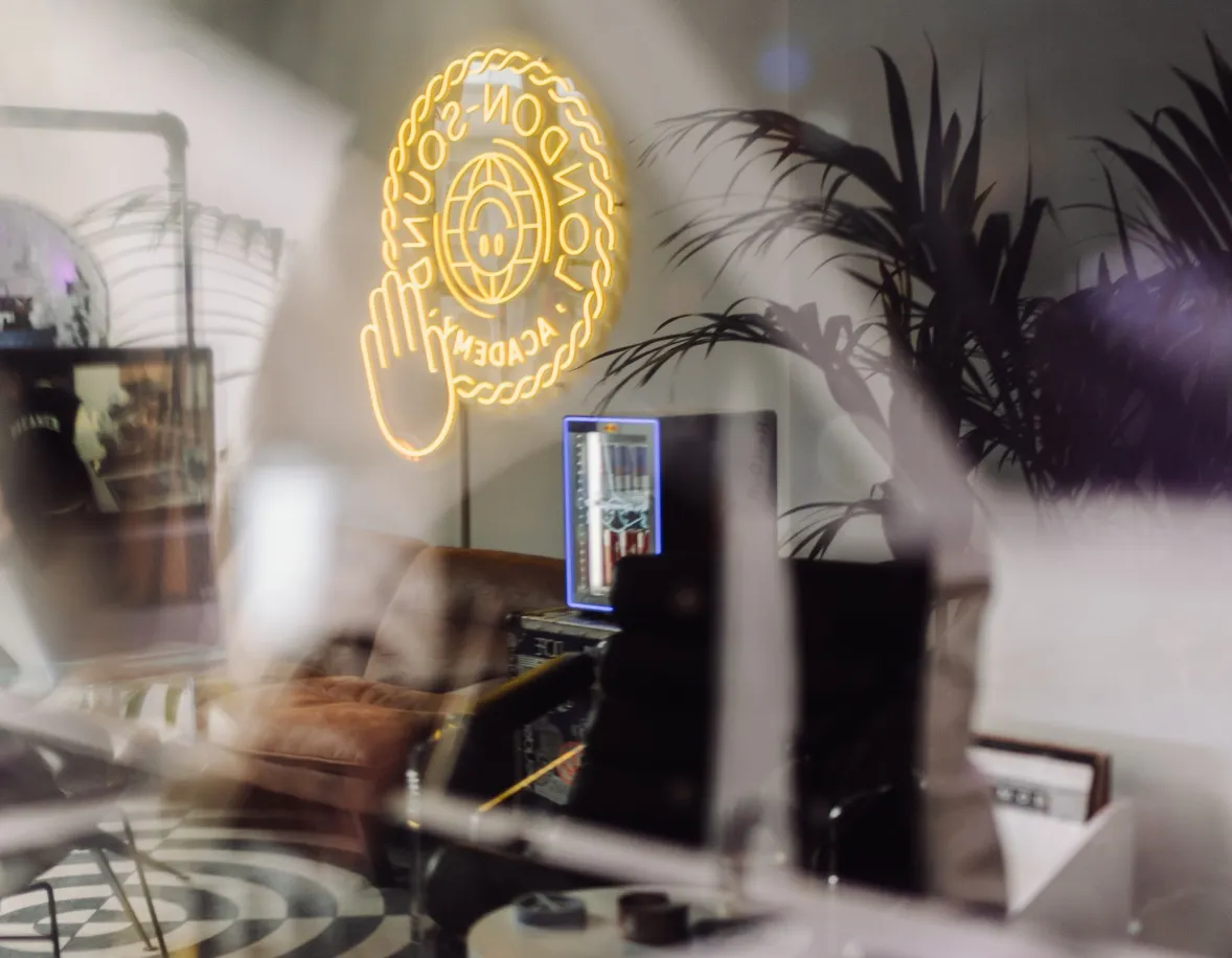 A view from the luxurious London Sound Academy DJ studios showing their neon sign, drinks fridge and plants