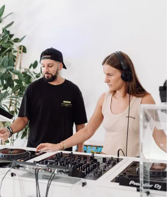An LSA DJ instructor teaching a student how to complete an advanced DJ transition with the lates DJ equipment